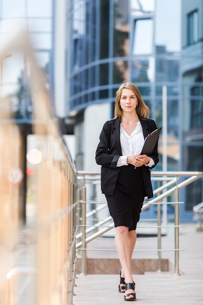 Woman with clipboard walking to camera