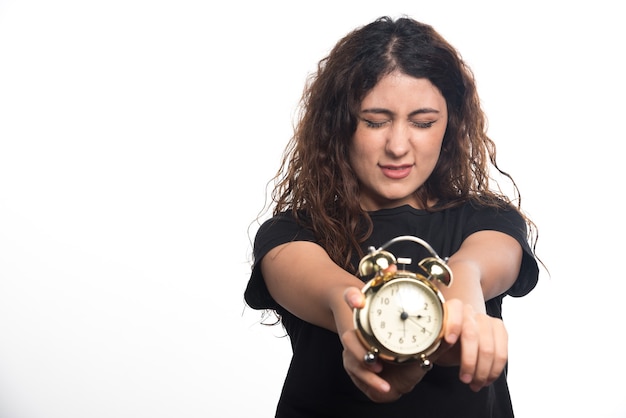 Foto gratuita donna con chiudere gli occhi che mostra una sveglia su sfondo bianco