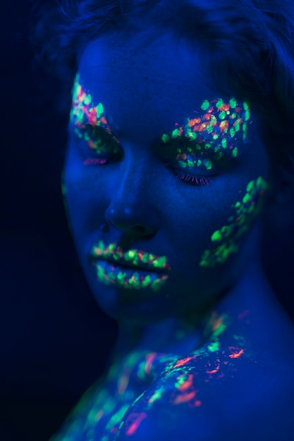 Бесплатное фото Женщина с глазами крупным планом и ультрафиолетовой краской
