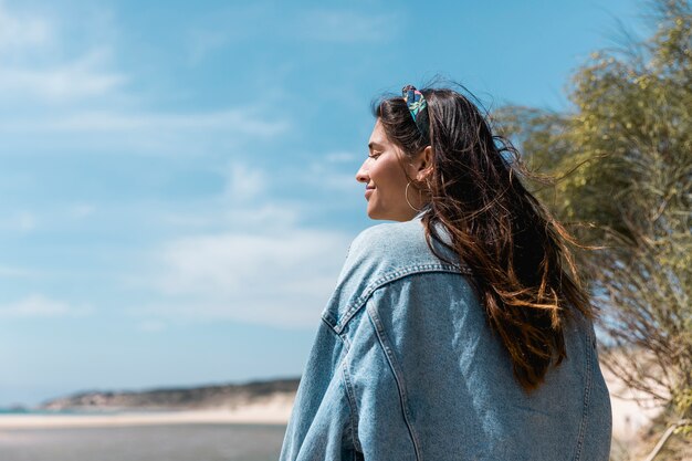 Woman with closed eyes sitting near tropical beach