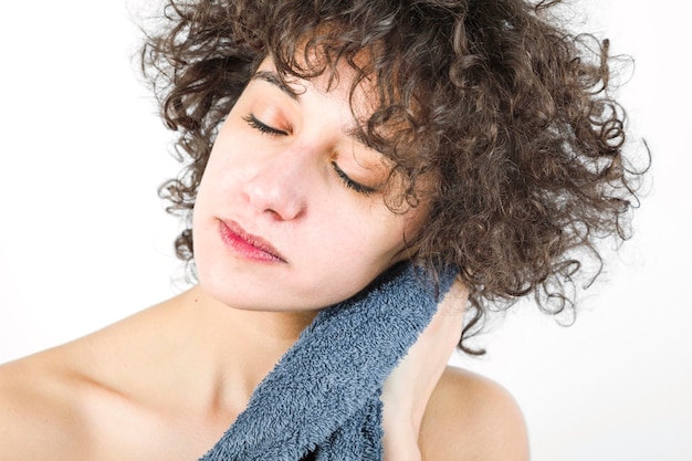 Woman with closed eyes wiping herself with towel