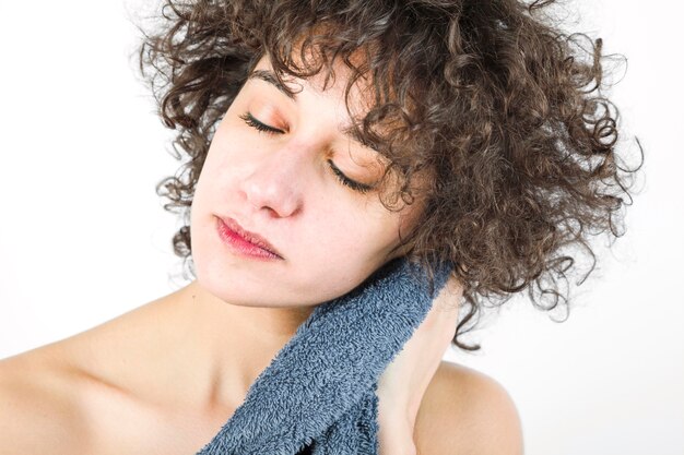 Woman with closed eyes wiping herself with towel