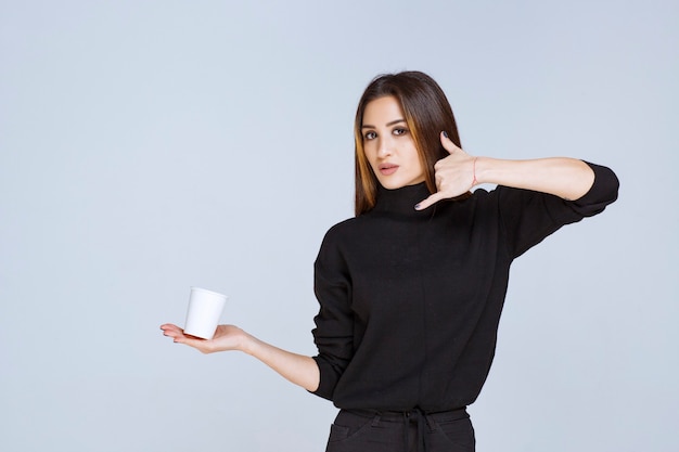 woman with a coffee cup asking for a call.