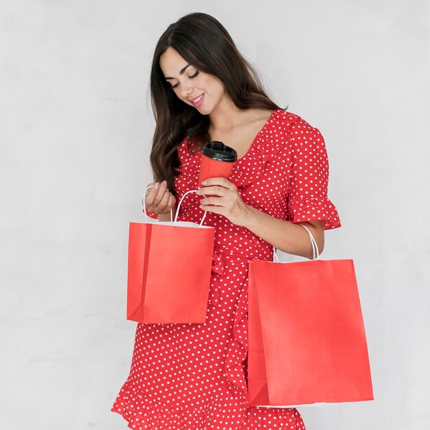 Woman  with coffee looking in the shopping bags