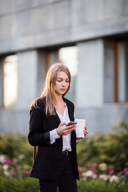 Woman with coffee and phone mid shot