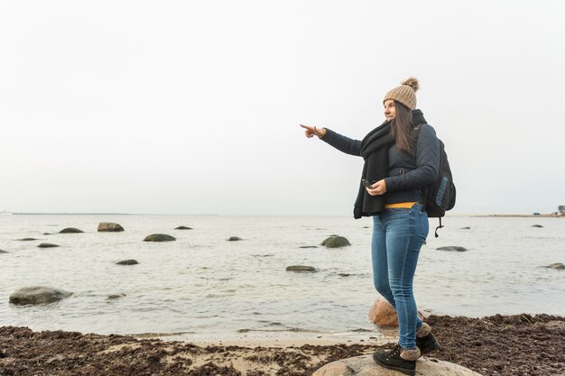 Woman with compass pointing at distance