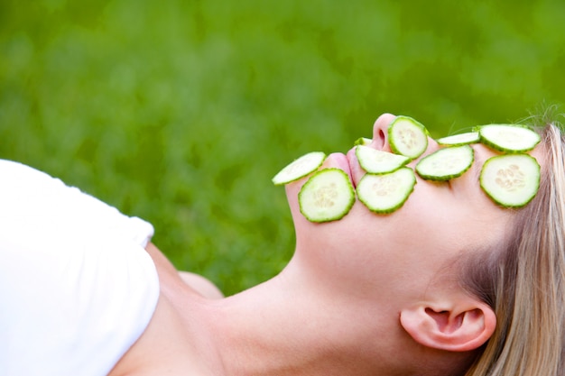 Woman with cucumber slices over her face