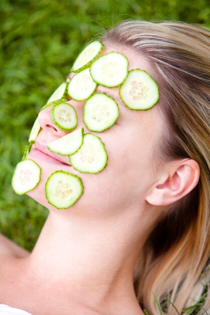 Woman with cucumber slices over her face