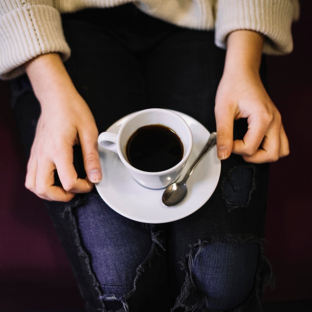 woman with cup of drink on plate