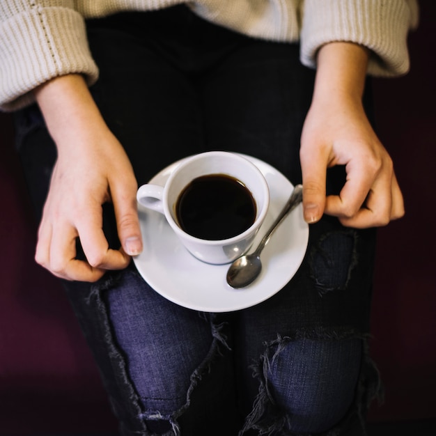 Woman with cup of drink on plate