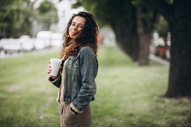 コーヒーを飲みながら巻き毛を持つ女性