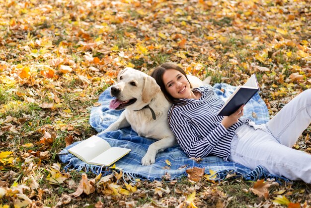 毛布の上に座っているかわいい犬を持つ女性