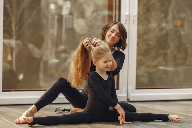 Woman with daughter is engaged in gymnastics