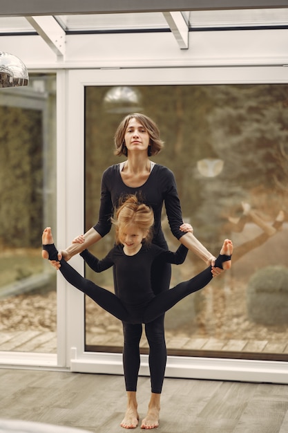 Woman with daughter is engaged in gymnastics