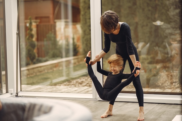 Woman with daughter is engaged in gymnastics