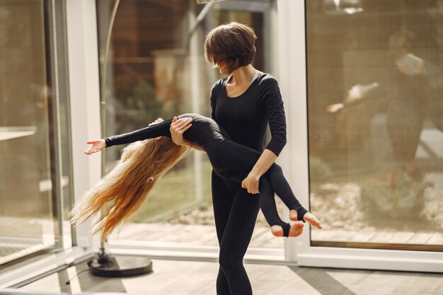 Woman with daughter is engaged in gymnastics