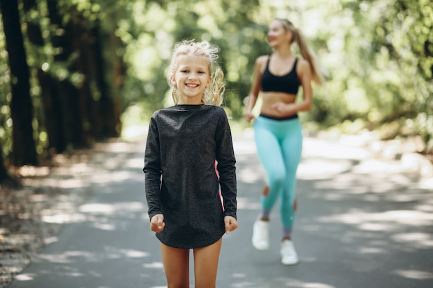 Woman with daughter jogging in park