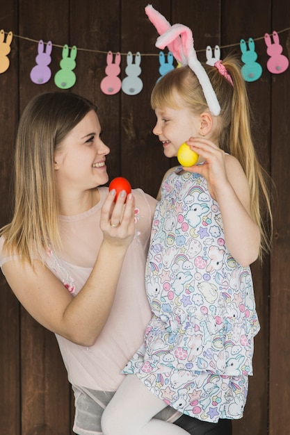 Foto gratuita donna con la figlia che gioca con le uova