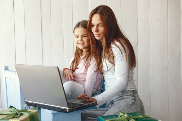 Женщина с дочерью с помощью портативного компьютера