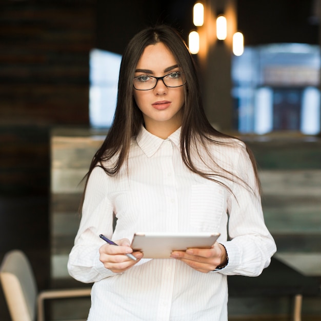 Foto gratuita donna con tavoletta digitale nella caffetteria