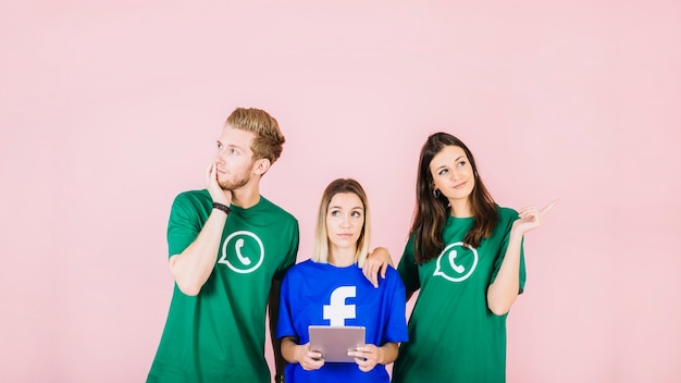 Free photo woman with digital tablet standing between her two thoughtful friends