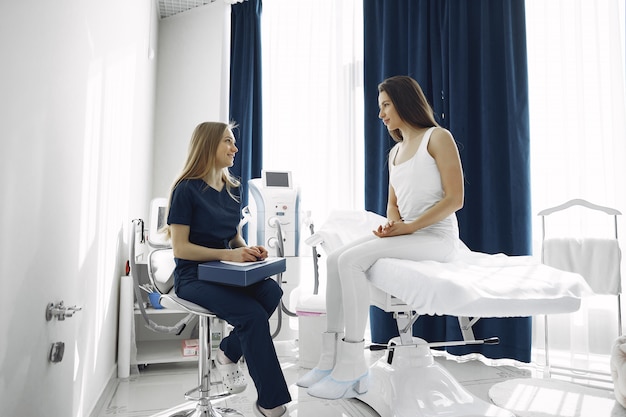 Woman with a doctor in cosmetology studio