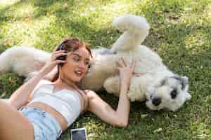 Free photo woman with dog outdoor listening music