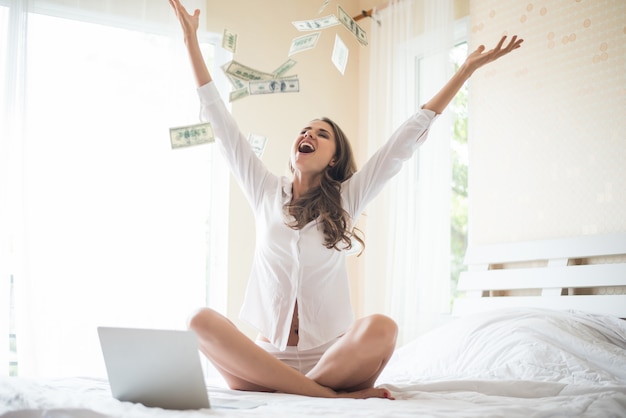 Woman with dollar bank note on the bed