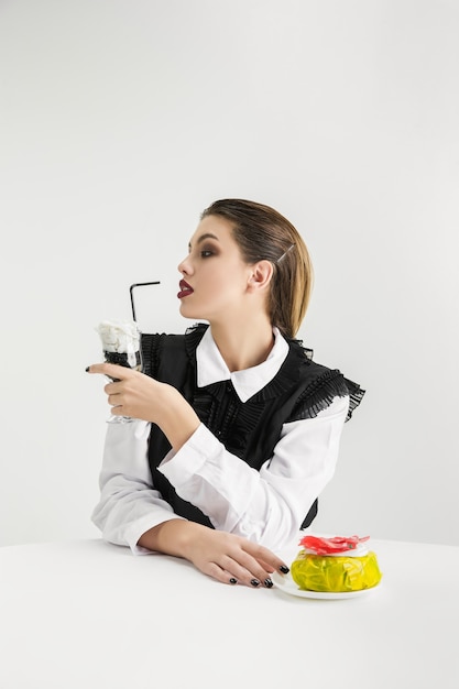 Free photo woman with donut, cocktail made of plastic, eco concept.