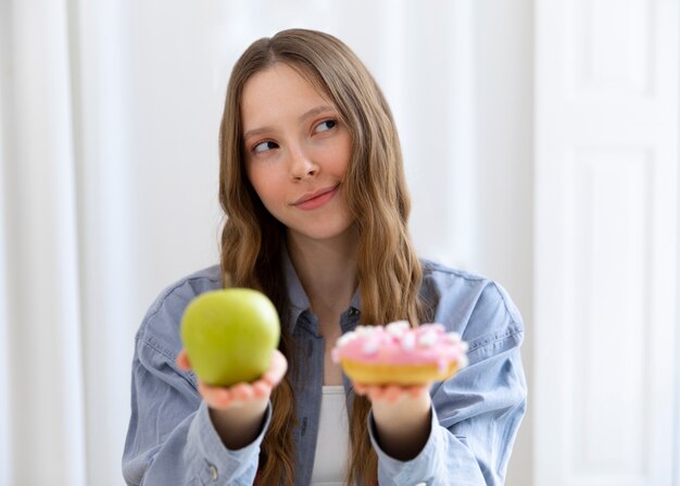 Woman with doughnut and apple