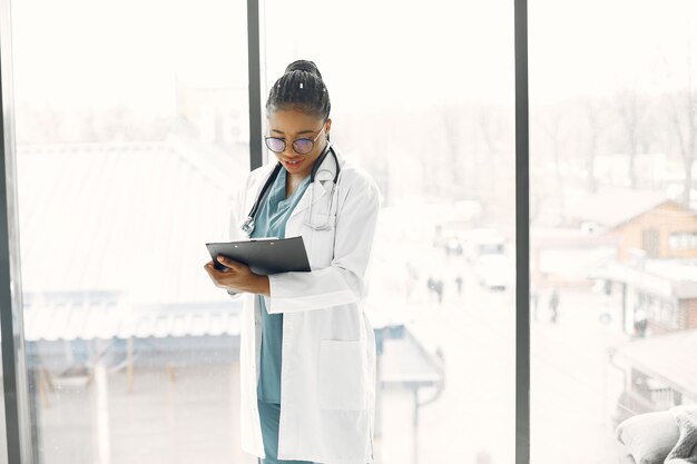 Woman with dreadlocks. Dark skinned doctor. Woman in a hospital gown.