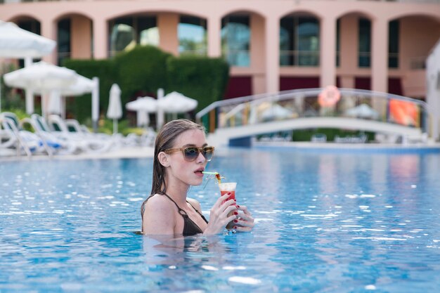 Woman with a drink in her hand in a pool