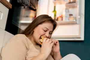 Foto gratuita donna con disturbo alimentare che cerca di mangiare al fast food