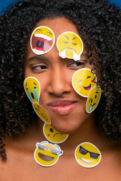 Free photo woman with emojis on face front view