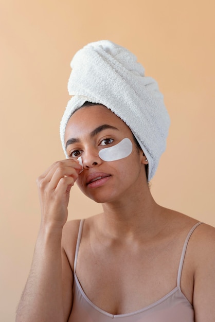 Free photo woman with eye patches and towel