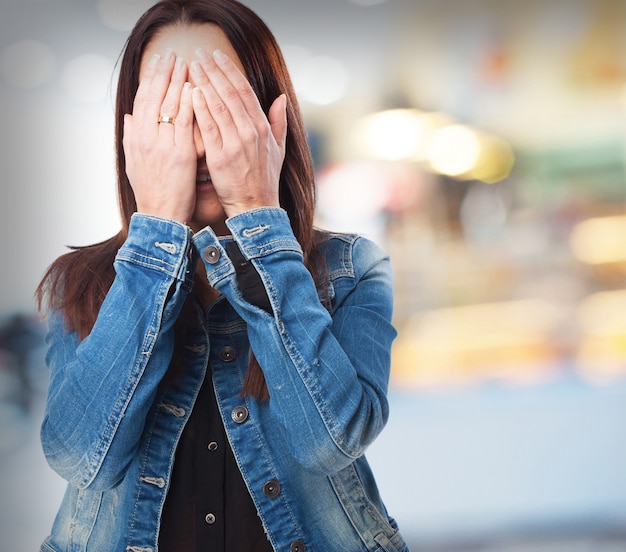 彼女の手で覆われた顔を持つ女性