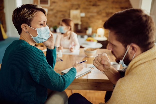 Free photo woman with face mask talking about her ill husband with a doctor over mobile phone