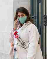 Free photo woman with face mask talking on the phone outdoors