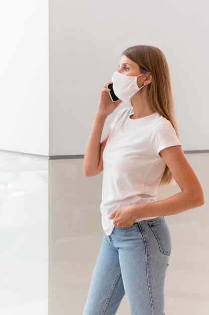 Woman with face mask talking on the phone