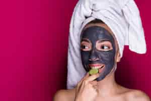 Foto gratuita donna con cetriolo degustazione maschera viso