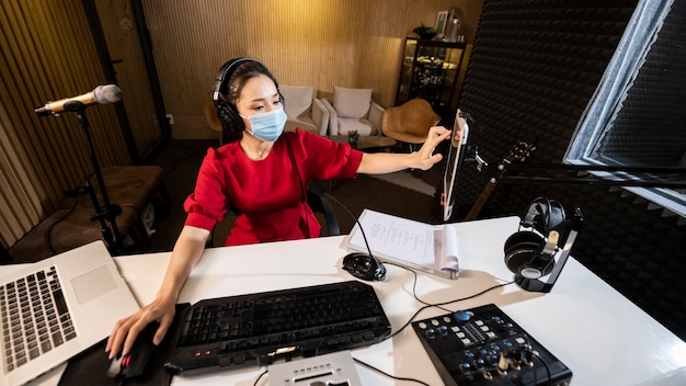 Free photo woman with face mask working at radio