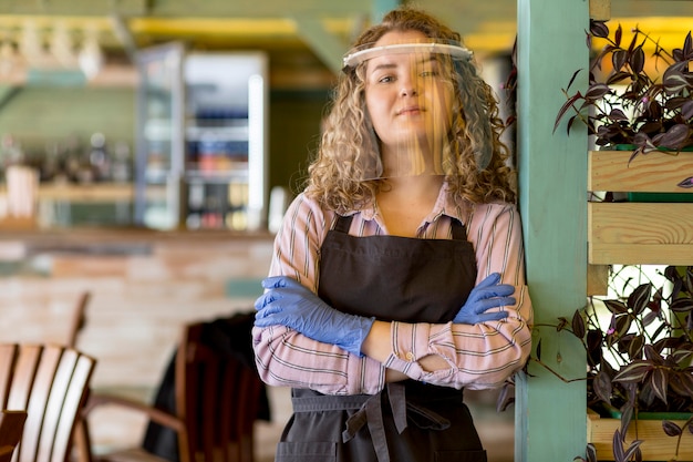 Free photo woman with face protection standing with arms crossed