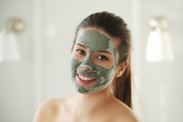 スキンケアのための顔のマスクを持つ女性。美容コンセプト。
