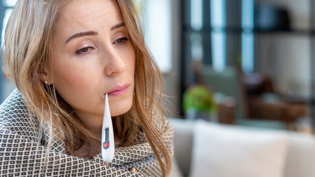 Woman with fever having a thermometer in her mouth