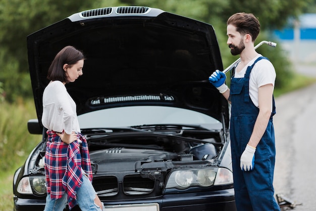 Woman with flannel and man holding wrench