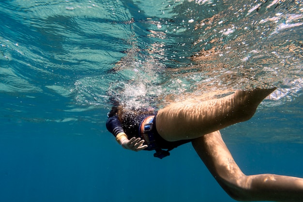 Foto gratuita donna con pinne nuotare nell'oceano