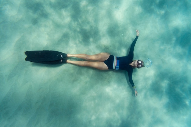 Foto gratuita donna con pinne nuotare nell'oceano