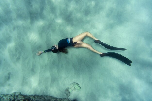 Woman with flippers swimming in the ocean