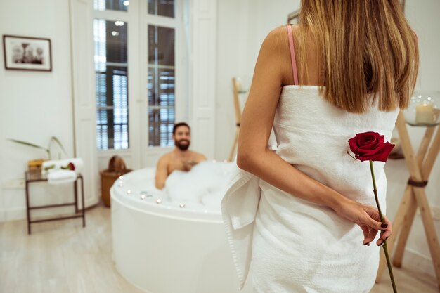 Woman with flower and man in spa tub with foam