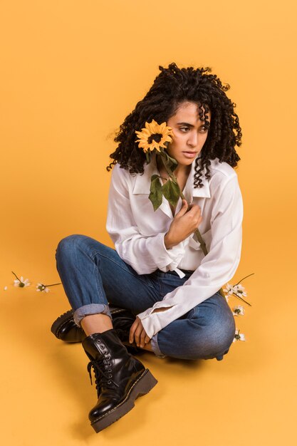 Woman with flower sitting on floor